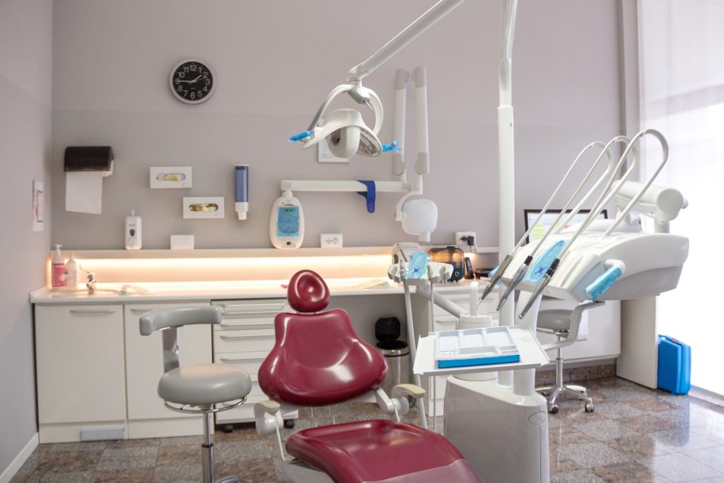 a-dental-room-with-a-red-chair-and-a-sink-dnerkdj0t7i