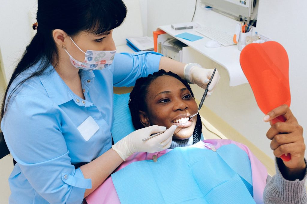 A female dentist checks a patients teeth during a dental appointment.